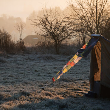 Bunte Gebetsfahnen im Winterlicht – spirituelle Atmosphäre bei der Jurte