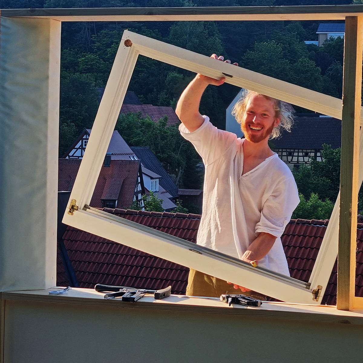 Mann mit Fensterrahmen beim Jurtenbau – Workshop zum Mitmachen