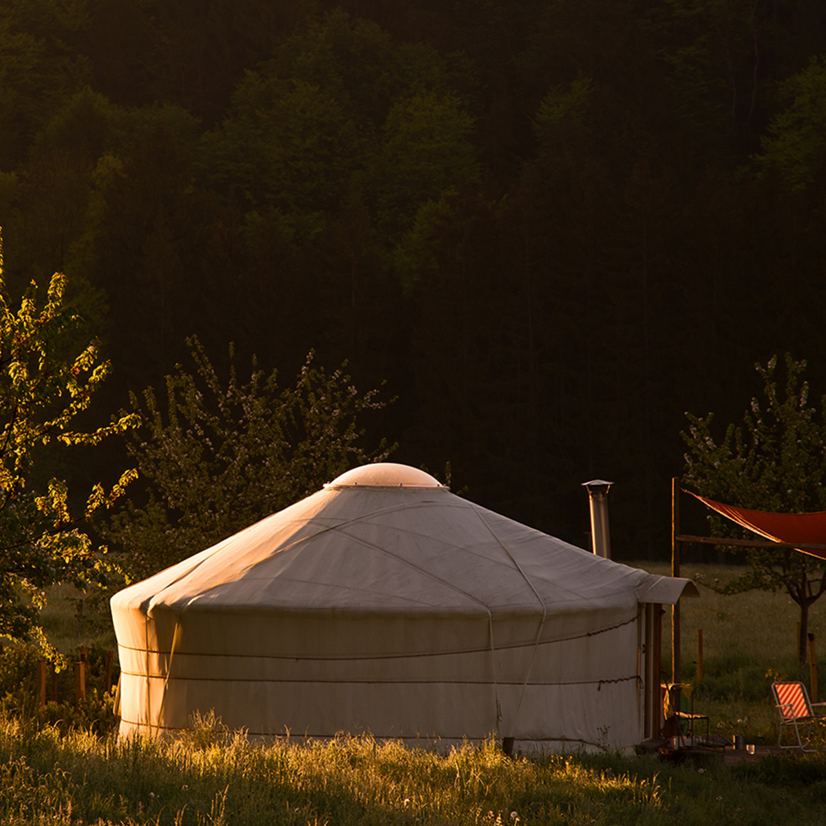 Jurte im Abendlicht am Waldrand – Symbol für naturnahes Leben und Gemeinschaft