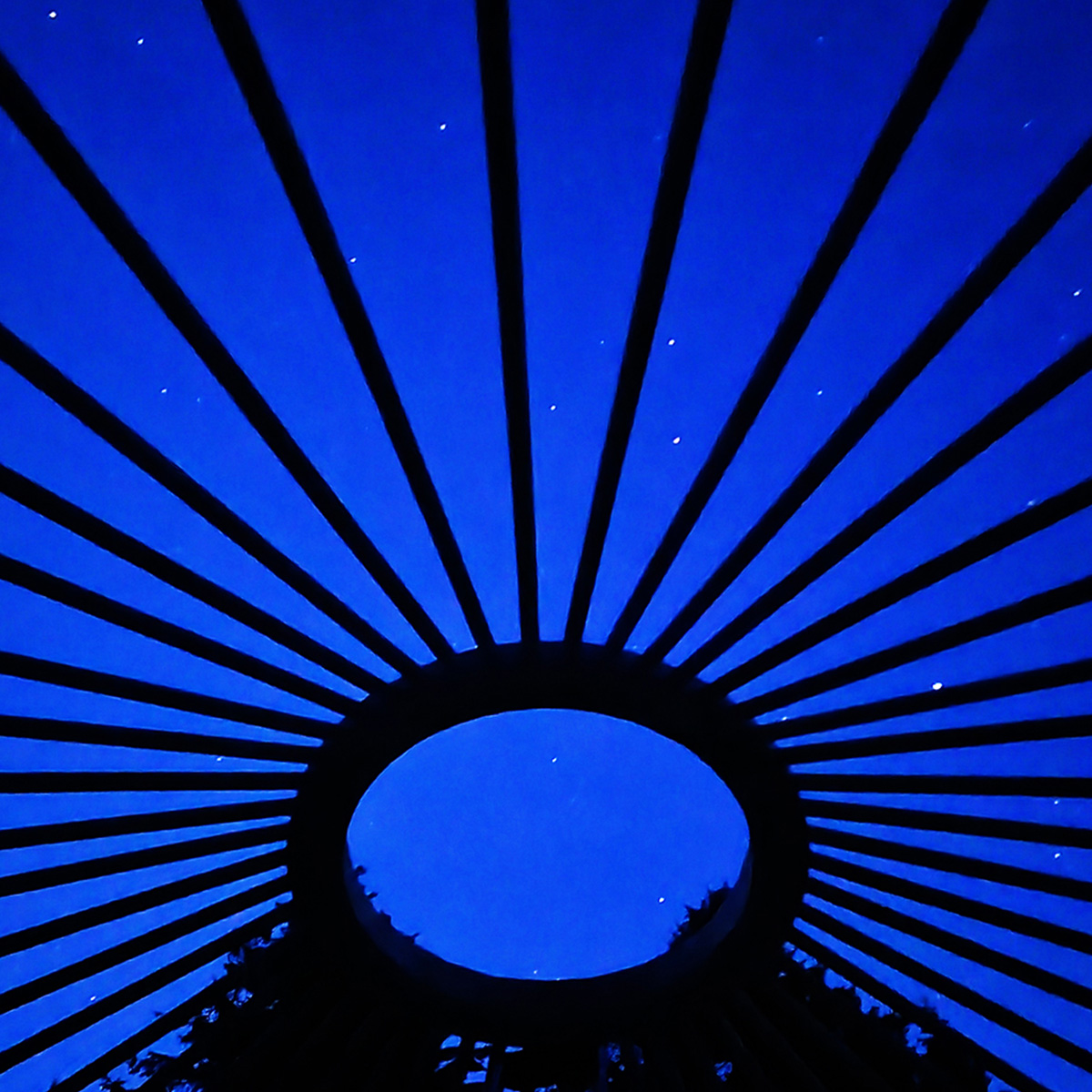 Blick in den Sternenhimmel durch das Dach einer Jurte bei Nacht