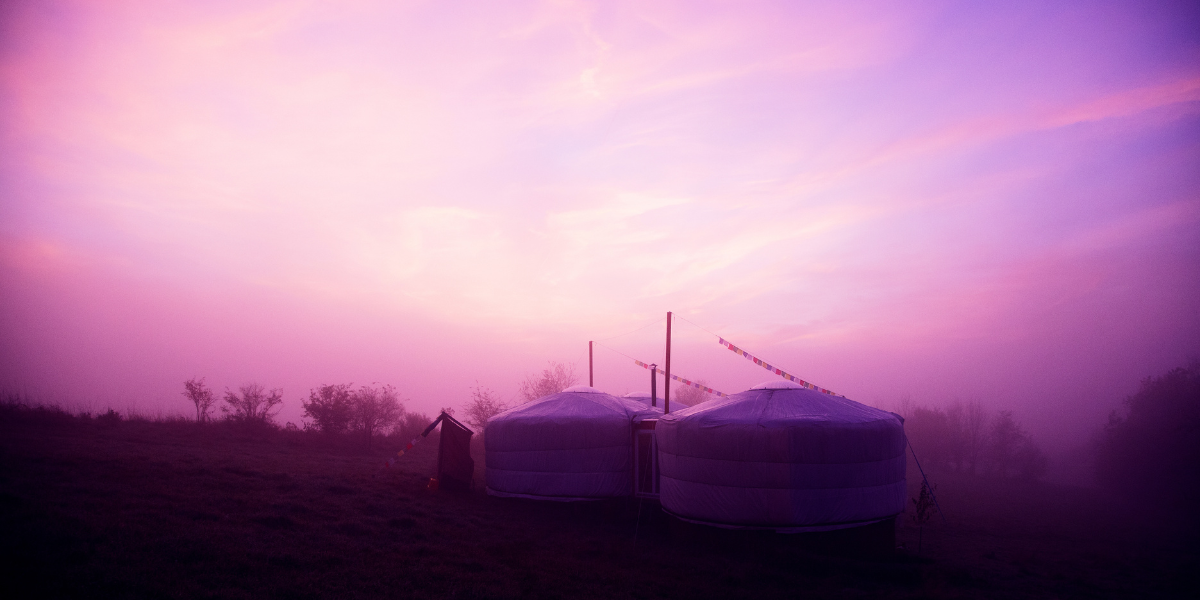 Beleuchtete Jurte im Schnee bei Dämmerung - Winterwohnen in der Jurte